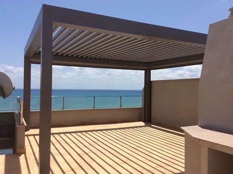 Pérgola bioclimática autoportante en un ático con vistas al mar